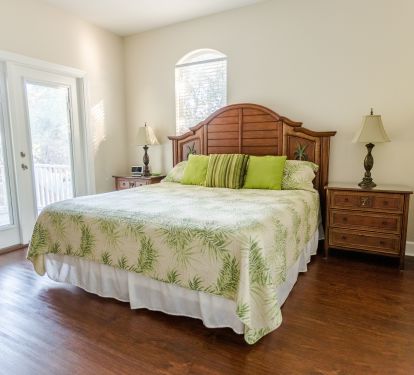 Second floor king bedroom with door to oversized porch overlooking huge yard
