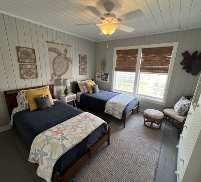 Beachy themed second bedroom with luxe twin beds and quality linens