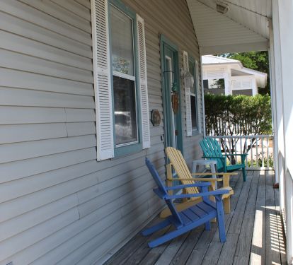Front porch with colorful Adirondack chairs