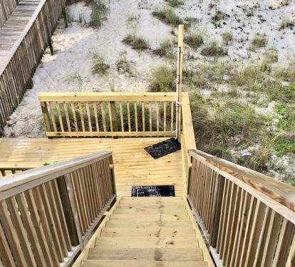 Stairs leading down to the beach with shower at bottom