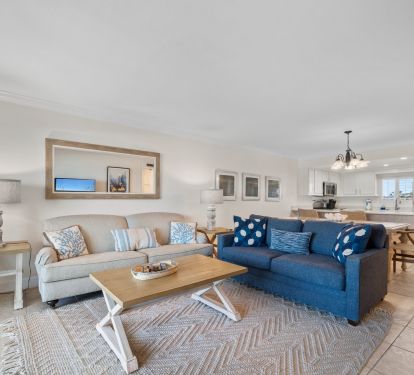 Living area with two sofas is open to the dining area and kitchen.