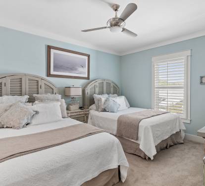 Bedroom two with two queen beds, adjoining make-up room with sink.