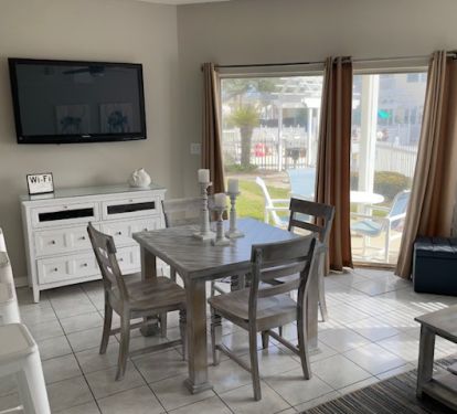 Dining area opens to back patio that is steps from grill and pool