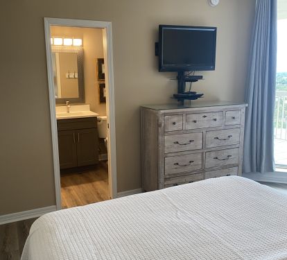 3rd Bedroom with ensuite bath, dresser, tv and shared balcony