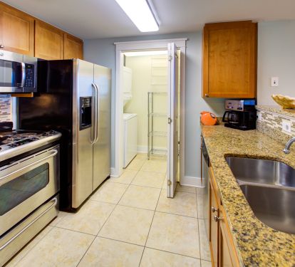 Open door to washer/dryer &amp; pantry-kitchen equipped for preparation of meals.