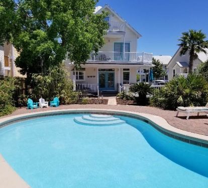 Backyard oasis with pool and dining area.