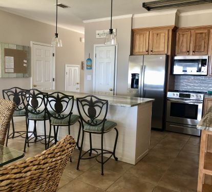 Spacious island kitchen with stone countertops and s/s appliances