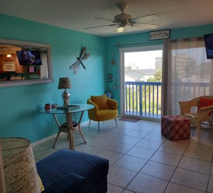 Livingroom with sliders to wrapped balcony with beach view and lagoon view.