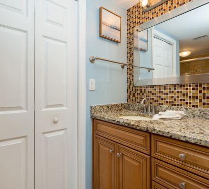 Master bathroom vanity features granite, upgraded cabinetry and tile accent wall