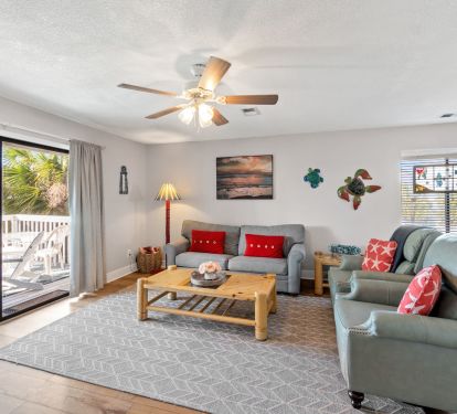 Living room with queen sleeper sofa and leather recliners. Smart TV on wall. 