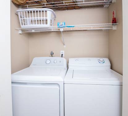The hallway laundry closet offers a full size washer and dryer