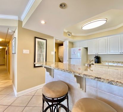 Fully stocked kitchen with raised ceiling and washer dryer combo in pantry