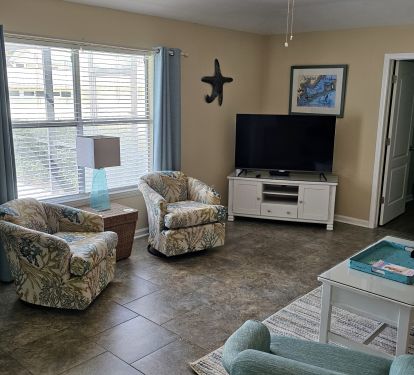 Living room w/ 3 swivel rocking chairs &amp; 55" Roku Tv