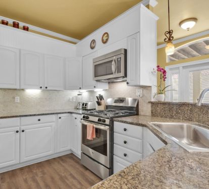 Kitchen with gas stove, microwave, toaster, coffee maker, and dishwasher.