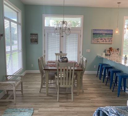 Dining room with seating at table and kitchen island.