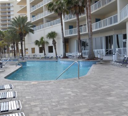 Large outdoor pool with beautiful water fountain and plenty of lounge chairs.
