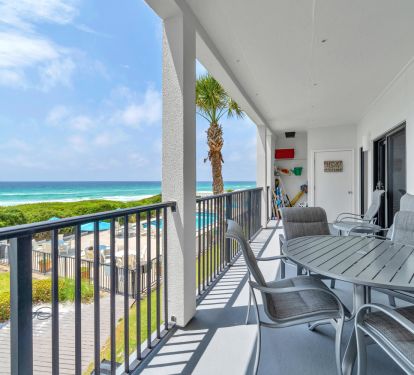 View of balcony with dining table, four dining chairs, two large chairs