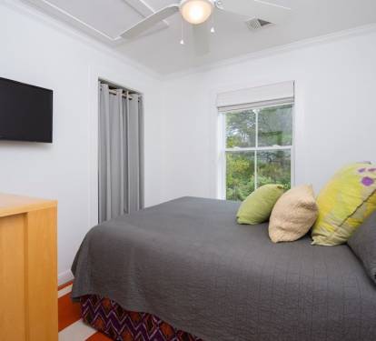 Master bedroom with queen bed, ceiling fan and flat screen TV