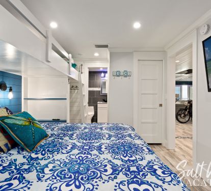 King bunk room with view of private  bathroom entrance 