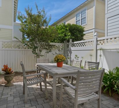 Backyard and patio is fenced in for privacy and has outdoor seating.