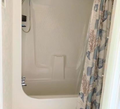 European bathroom with toilet and sink in one room and shower in separate room