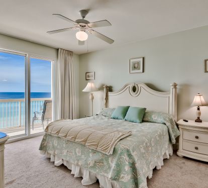 Master bedroom with King sized bed and sliding glass door to balcony