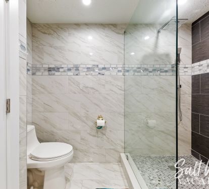 Walk in master bathroom with custom tile and LED water sensors 