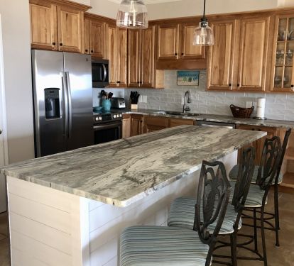 Spacious island kitchen with stone countertops and s/s appliances