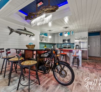 Unique driftwood chandelier with LED lighting above motorcycle dining table 
