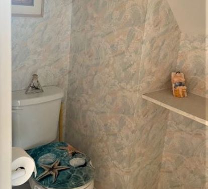 European bathroom with toilet and sink in one room and shower in separate room