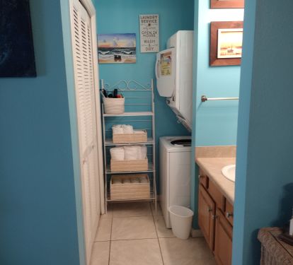 Washer and dryer with bathroom sink and large closet.