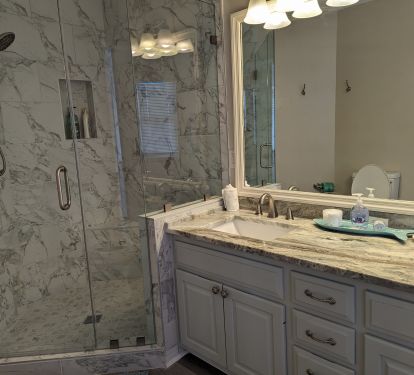 Updated MB w tile to the ceiling, glass doors, and granite counters