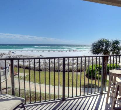 Spectacular view of the gulf and pool from balcony with lounge and dining set