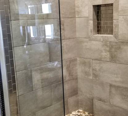 Master shower with rain head, linear drain, stone floor and seamless glass