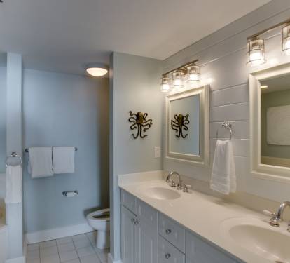 Master Bathroom #1 has duel vanities and a coastal wood panel accent wall.