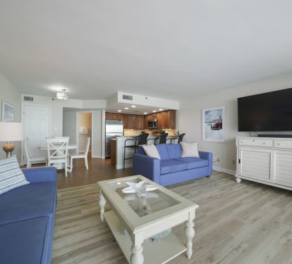 Family-friendly living room with a large smart tv that flows into the dining space and kitchen