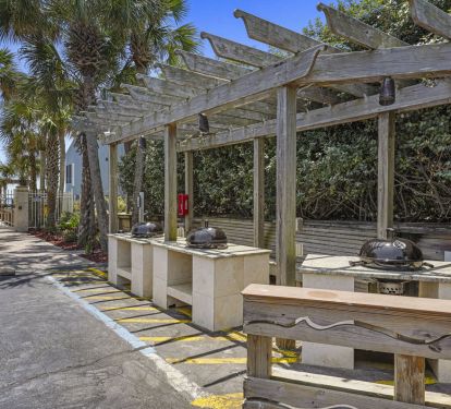 Destin, FL beachfront property with shaded pergola and community BBQ area