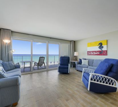 This spacious beachfront living area offers panoramic views of the Emerald Coast through large sliding glass doors, creating the perfect place to relax after a day on the beach.