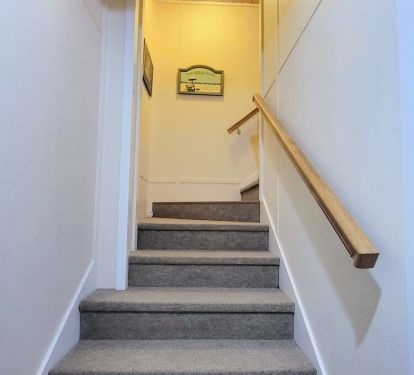 Low pile carpet and sturdy wooden rails make navigating the stairs between floors safe and easy.