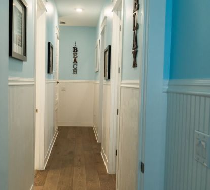 Classic hallway view with beadboard and coastal art.