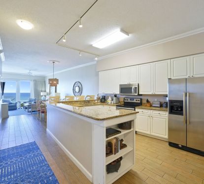 Open-concept kitchen with granite countertops and Gulf-view living area