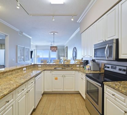 Bright beachfront condo kitchen leading to balcony and Gulf views