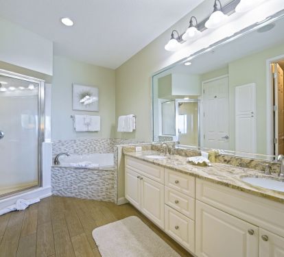 Bright primary bathroom with double vanity and spa-style tub