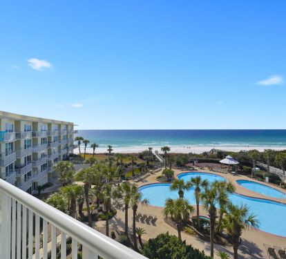 Destin beachfront condo balcony overlooking lagoon pool and white sand beach