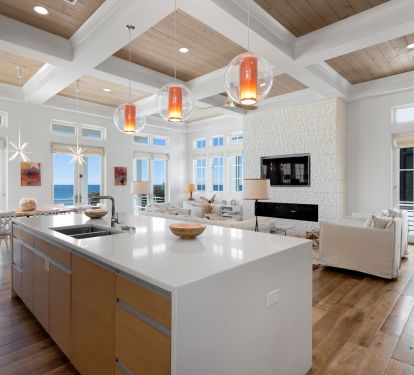 Your stunning open-concept space seamlessly blends kitchen and living areas, where modern pendant lights illuminate the sleek island and ocean views await.