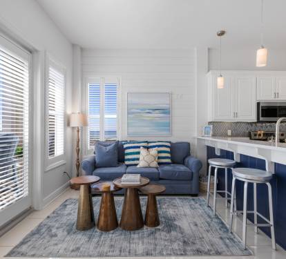 Your bright coastal retreat features an open-concept living space where blue accents meet crisp whites, creating the perfect backdrop for your beach getaway.