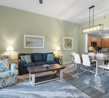 Settle into your spacious open-concept living area where coastal blues meet warm wood tones, creating the perfect space to unwind after your adventures.