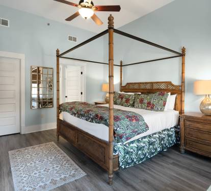Unwind in your elegant four-poster bed surrounded by soothing coastal hues and tropical bedding that whispers of island dreams.