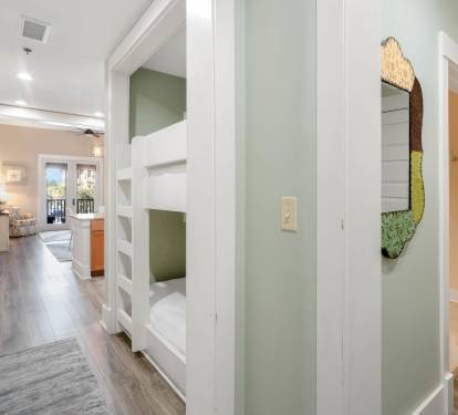 Step into your stylish hallway where thoughtful design meets comfort—built-in bunks create cozy sleeping nooks while warm wood floors guide you through this welcoming space.