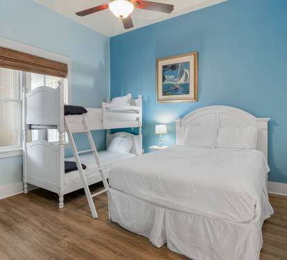 Relax in your coastal-themed bedroom with comfortable beds and soothing blue walls that create a peaceful seaside retreat.